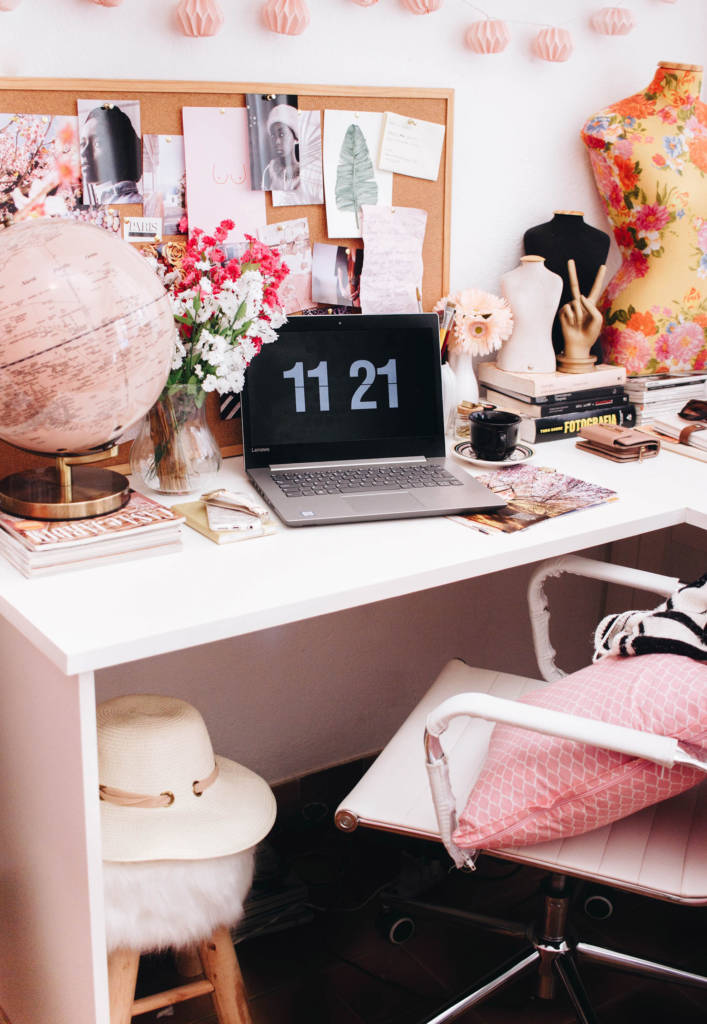 Aseguranza Medica Barata Trabajador Independiente en Fotografia con escritorio y silla blanca con laptop negra, globo de mundo rosa, almohada rosa, flores y decoracion femenina